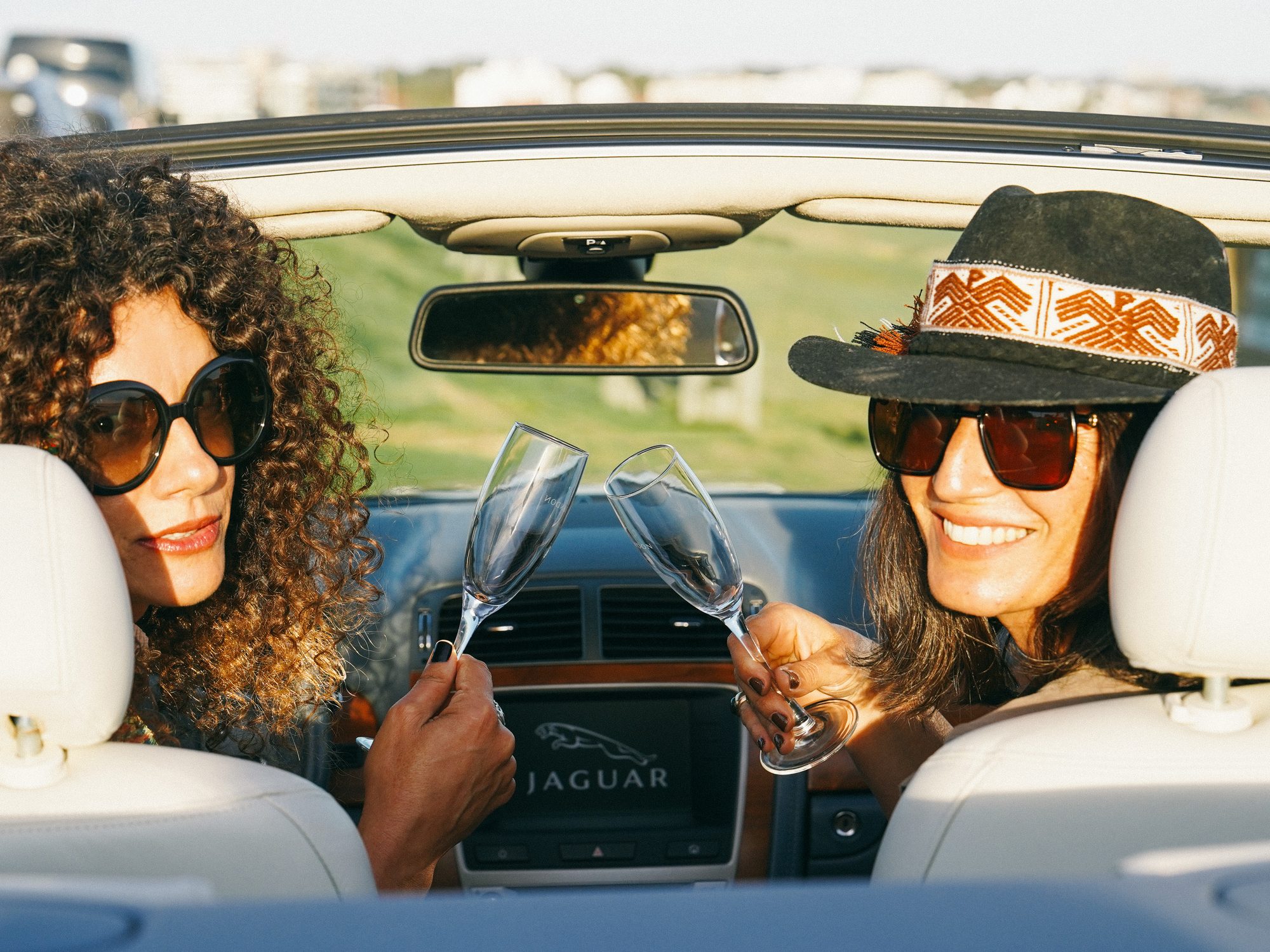 Guests toasting in a Jaguar convertible
